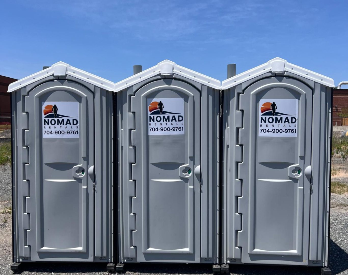 Nomad Rentals team placing portable toilets for construction project needs.